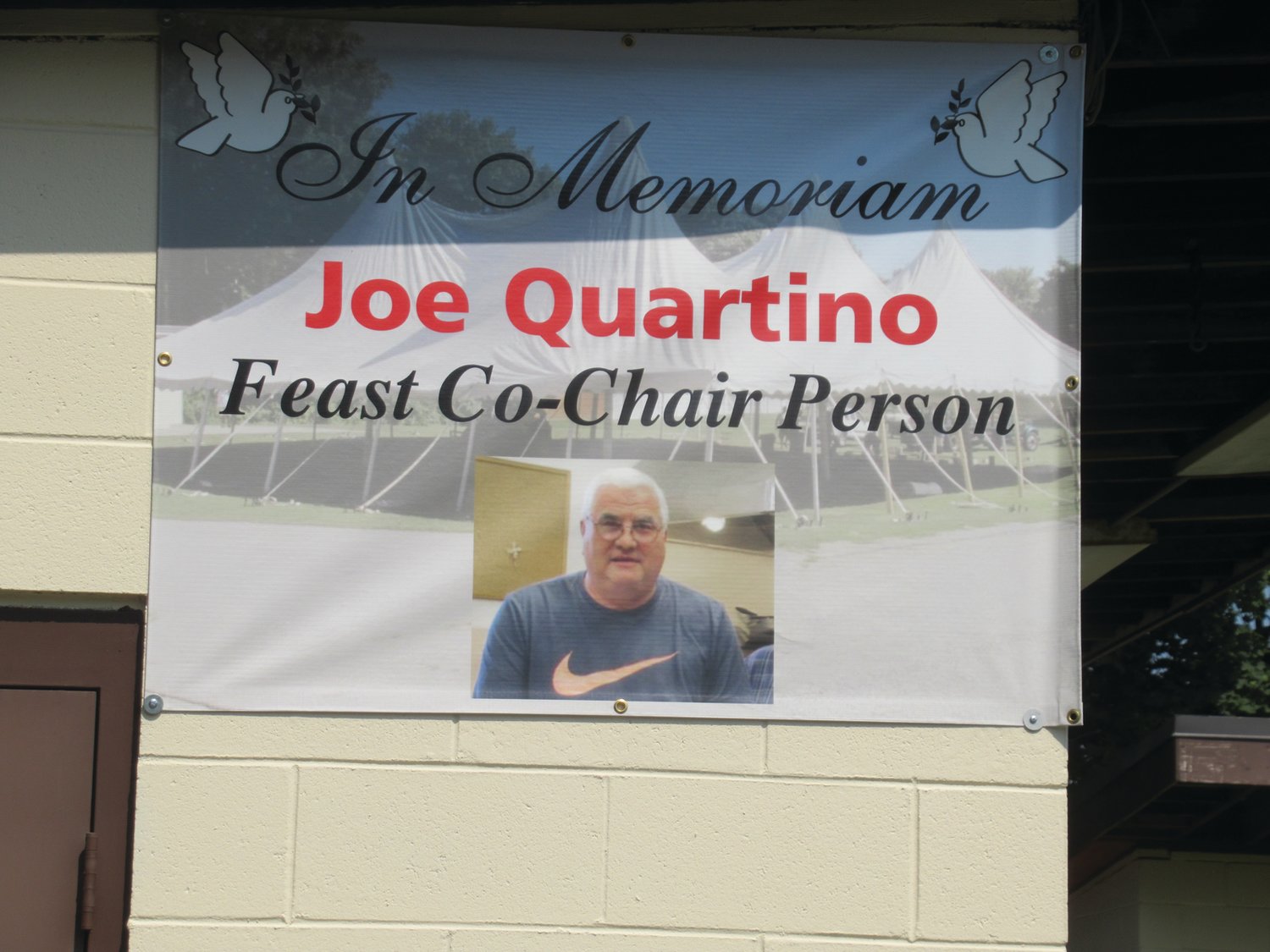 MIGHTY MEMORIAL: This is a special sign made in memory of the late Joe “Joe Q” Quartino, the man for all seasons and reasons at our Lady of Grace Church who served as co-chairman of the feast for many, many years until his unfortunate passing last year.